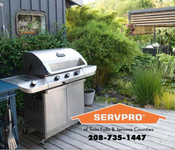 An outdoor kitchen is shown with a propane grill. 