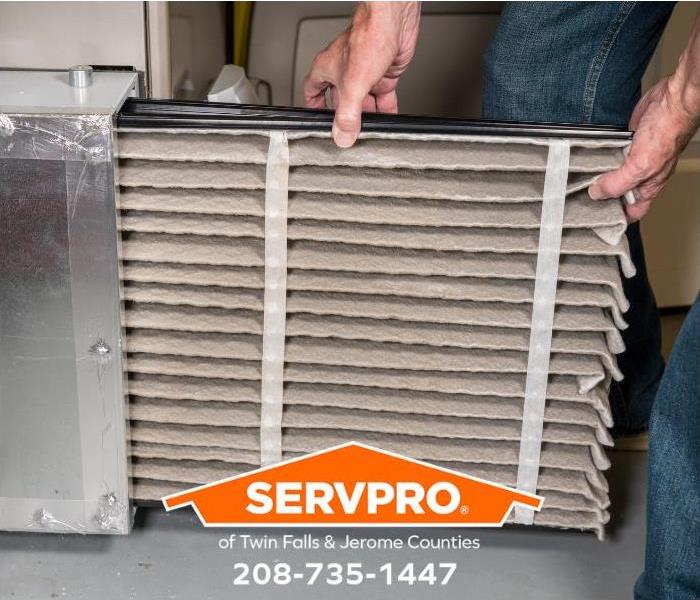 A person is changing an HVAC filter.