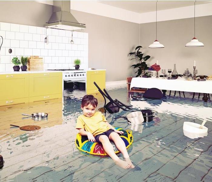 boy on innertube in a flooded kitchen